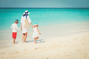 Anne ile küçük oğlu ve kızı yürüyüş sahilde