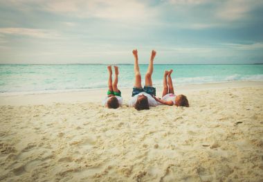 Baba ve küçük oğlu ve kızı plajda oyna