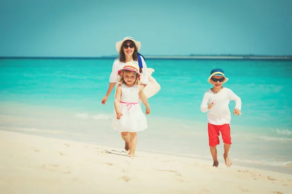 Moeder met kleine zoon en dochter wandeling op strand — Stockfoto