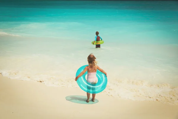 Bambina e ragazzo andare a nuotare sulla spiaggia — Foto Stock