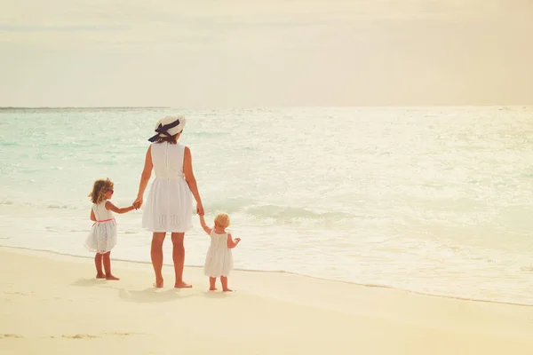 Matka s dvěma dcerami procházka na pláži — Stock fotografie