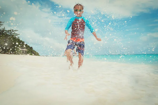 Szczęśliwy chłopiec run gra z fale na plaży — Zdjęcie stockowe