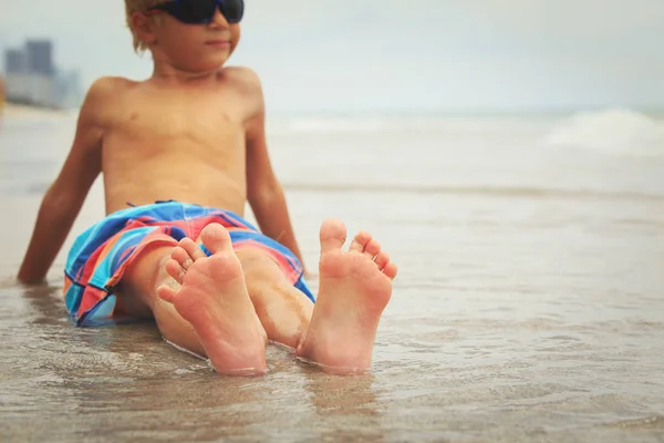 Stóp małego chłopca zrelaksować się na plaży latem — Zdjęcie stockowe