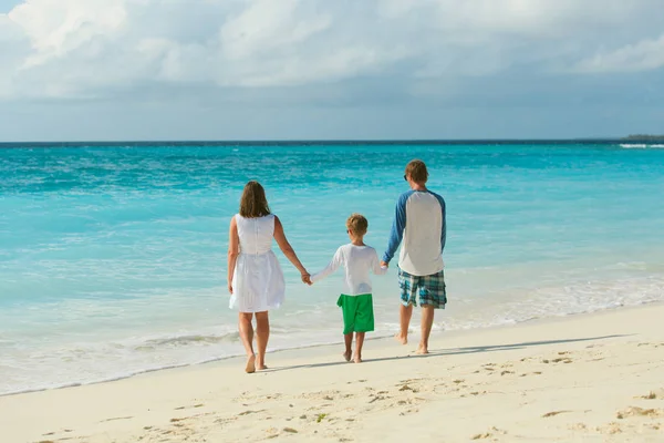 Family with kid walking on beach — Stock Photo, Image