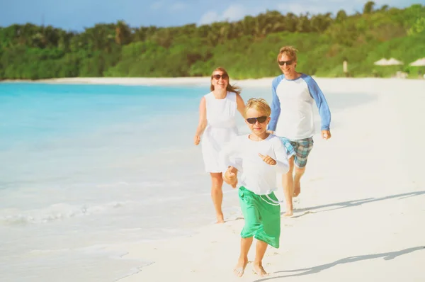 Familia feliz con juego de niños correr en la playa — Foto de Stock