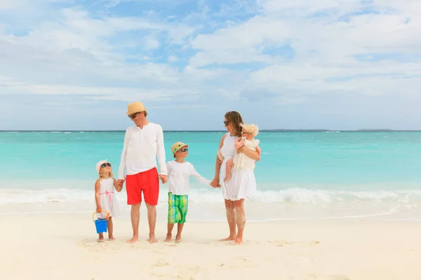 Счастливая семья с тремя детьми гуляет по пляжу — стоковое фото