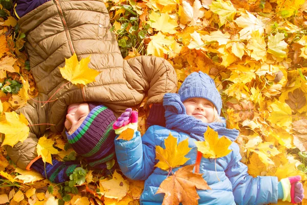 Kids having fun in autumn fall leaves — Stock Photo, Image