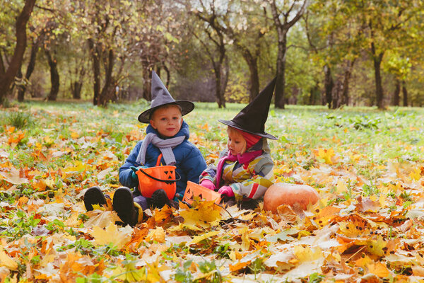 kids in halloween costume play in autumn
