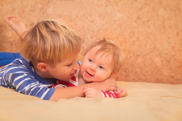 Little boy play with little newborn sister at home — Stock Photo, Image