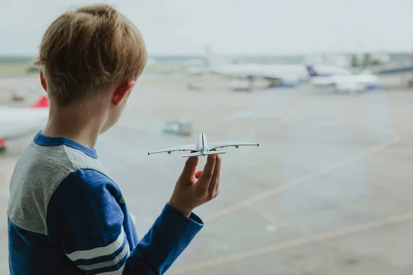 Хлопчик грає з іграшковим літаком під час очікування в аеропорту — стокове фото