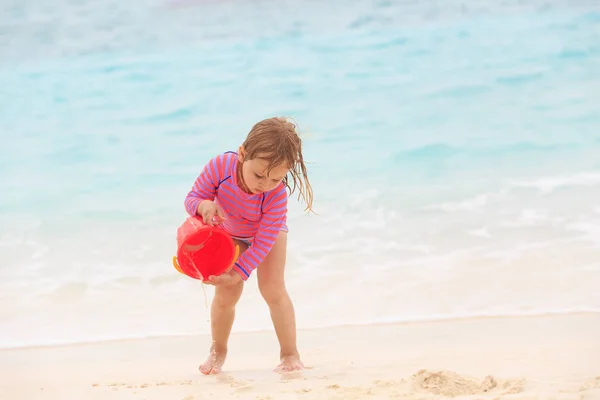 Schattig klein meisje spelen met zand en water op het strand — Stockfoto