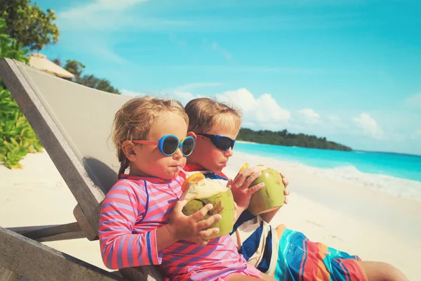 Malý chlapec a dívka pití kokosové na pláži — Stock fotografie
