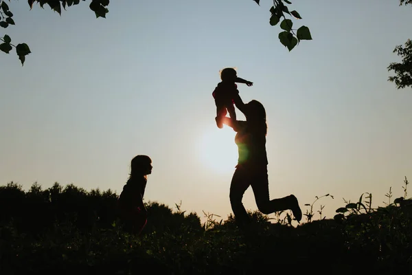 Madre con due bambine giocano al tramonto — Foto Stock