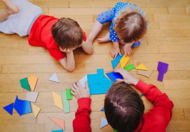 öğretmen ve geometrik şekillerle oynayan çocuklar