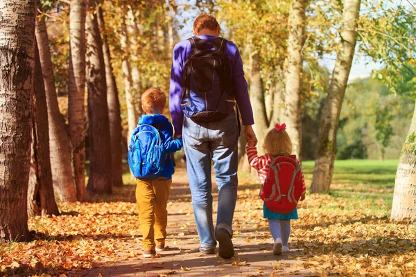 Pai com pequeno filho e filha indo para a escola — Fotografia de Stock