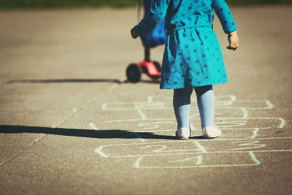 Menina jogar hopscotch no playground — Fotografia de Stock