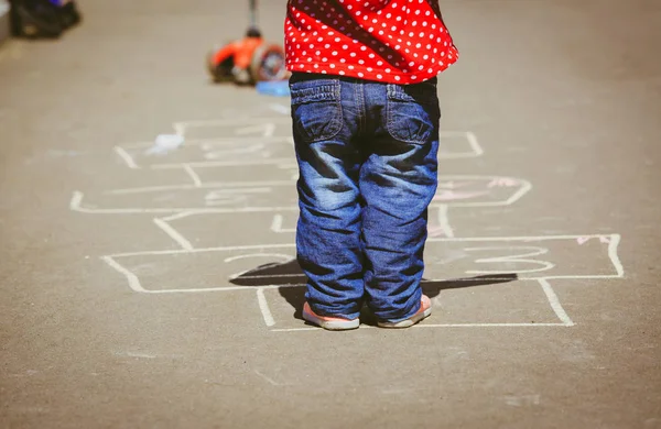 Gadis kecil bermain hopscotch di taman bermain — Stok Foto