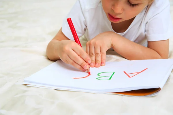 Маленький мальчик учится писать письма — стоковое фото
