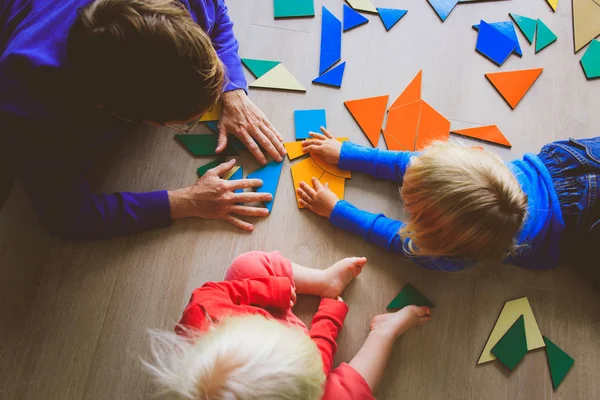 Leerkracht en kinderen spelen met puzzel — Stockfoto