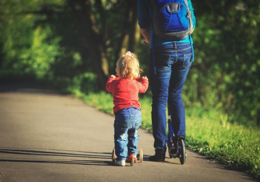 Anne ve küçük kızı scooter, etkin aile spor sürme