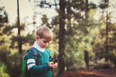 küçük çocuk yeşil ormanda pusula ile seyahat