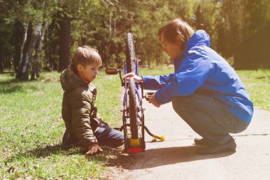 Baba ve oğul doğada Bisiklet tamir