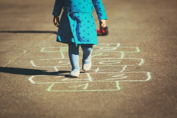 Kleines Mädchen spielt Hopscotch auf Spielplatz — Stockfoto