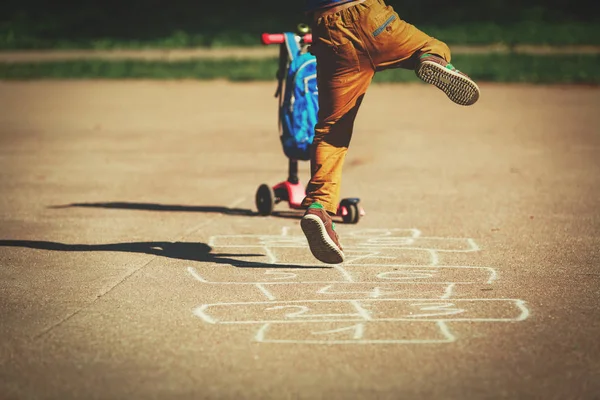 Petit garçon jouer marelle sur aire de jeux — Photo