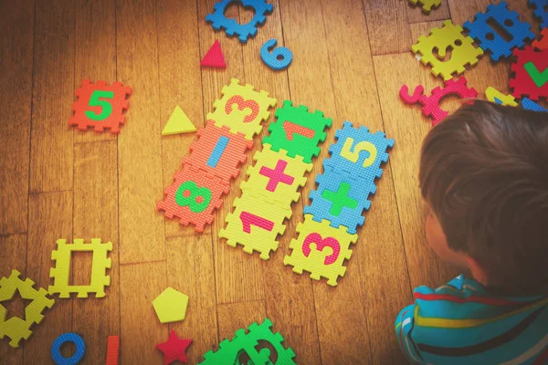 Bulmaca, eğitim kavramı ile oynarken küçük çocuk