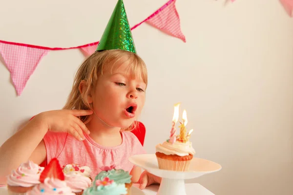 Feliz niña hacer deseo soplar velas en fiesta de cumpleaños —  Fotos de Stock
