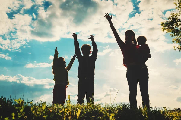 Família feliz com três crianças na natureza por do sol — Fotografia de Stock