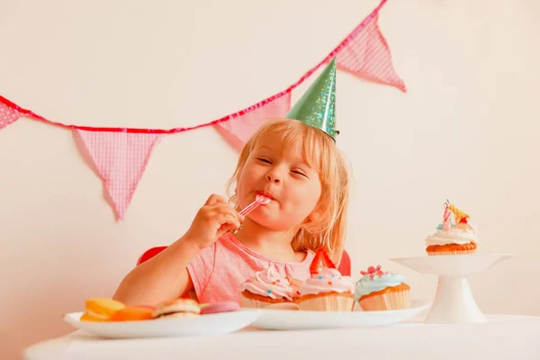 Heureuse petite fille manger des bonbons à la fête d'anniversaire — Photo