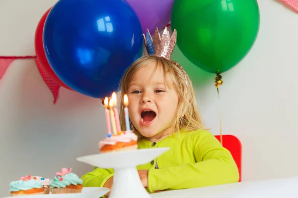 Feliz niña hacer deseo soplar velas en fiesta de cumpleaños — Foto de Stock