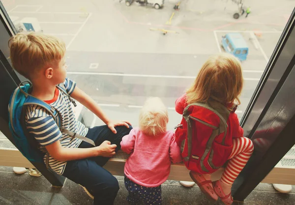 Niño y dos niñas mirando aviones en el aeropuerto — Foto de Stock