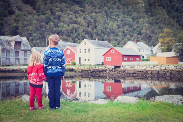 Маленький мальчик и девочка путешествия глядя на традиционную деревню в Норвегии — стоковое фото