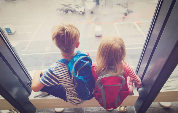 Мальчик и девочка смотрят на самолеты в аэропорту — стоковое фото