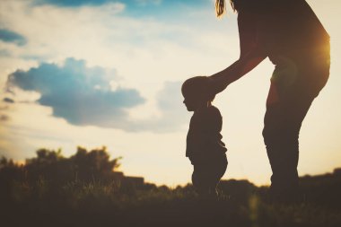 Anne ve bebek ilk adımları günbatımında yapma