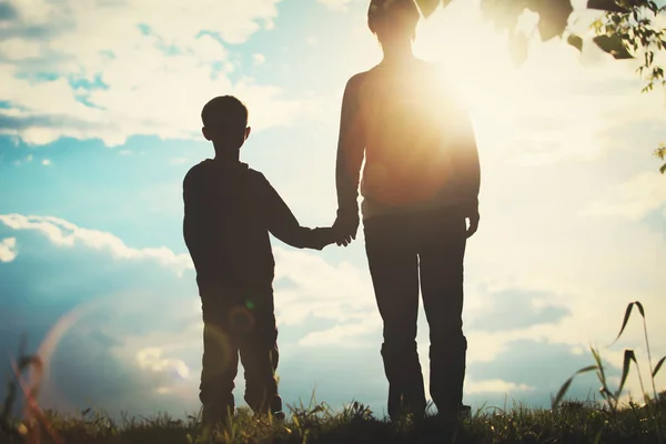 Silhouette von Vater und Sohn beim Händchenhalten bei Sonnenuntergang — Stockfoto