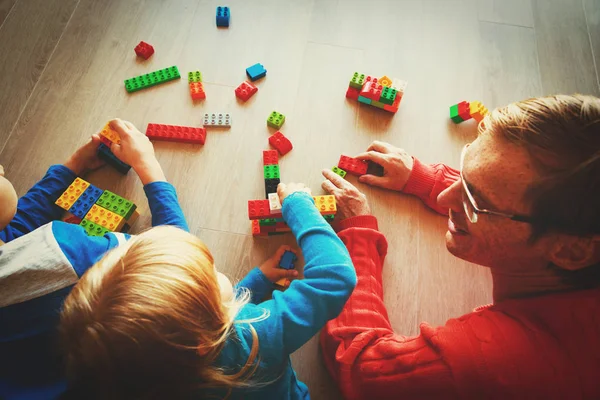 Professor e crianças brincando com blocos de plástico — Fotografia de Stock
