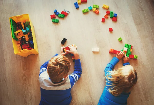 Liten pojke och flicka spela med plast block — Stockfoto