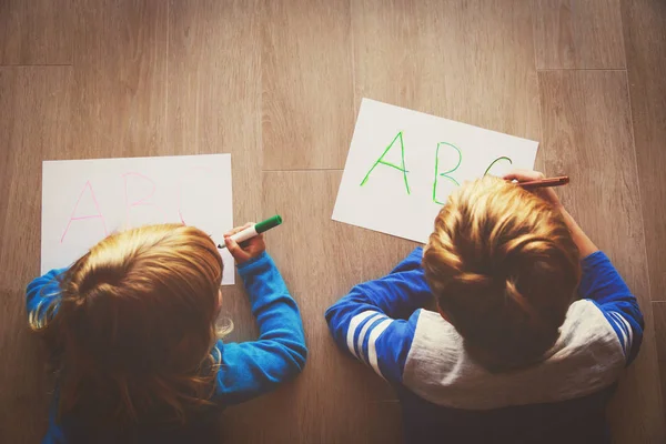 As crianças aprendem a escrever cartas, a fazer trabalhos de casa — Fotografia de Stock
