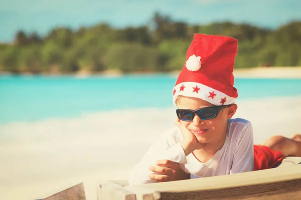 Menino comemorando o Natal na praia tropical — Fotografia de Stock