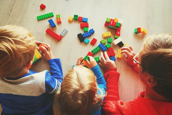 Professeur et enfants jouant avec des blocs en plastique — Photo