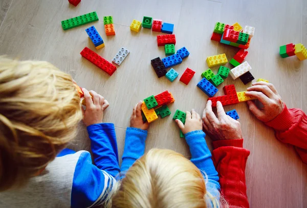 Professor e crianças brincando com blocos de plástico — Fotografia de Stock