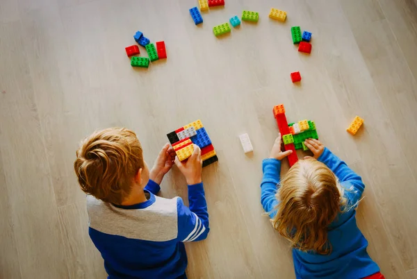 Liten pojke och flicka spela med plast block — Stockfoto