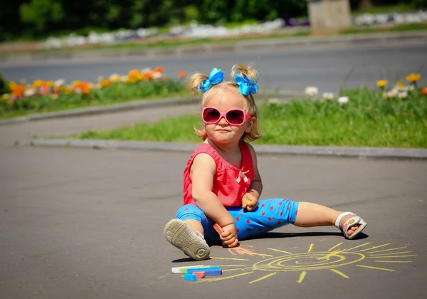 Cute dziewczynka rysunek słońce na ulicy — Zdjęcie stockowe