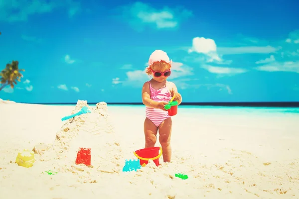 Linda niña jugar con arena en la playa —  Fotos de Stock