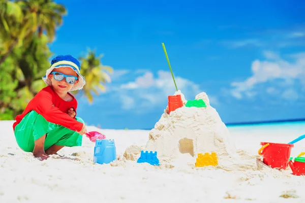 Niño pequeño edificio castillo de arena en la playa —  Fotos de Stock