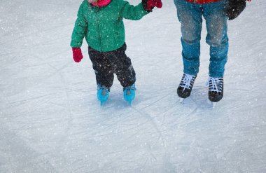 Baba ve küçük kızı kışın paten için öğrenme