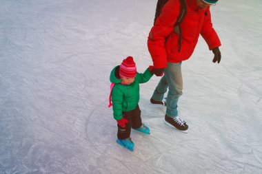 Baba ve küçük kızı kışın paten için öğrenme